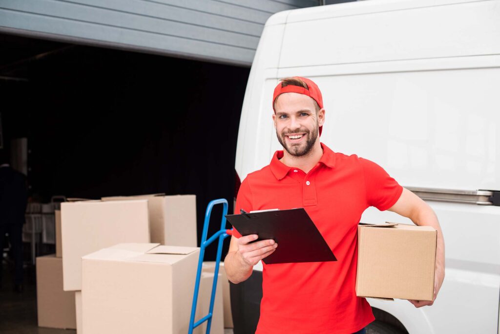 portrait-of-young-smiling-delivery-man-with-cardbo-PA86WFD.jpg